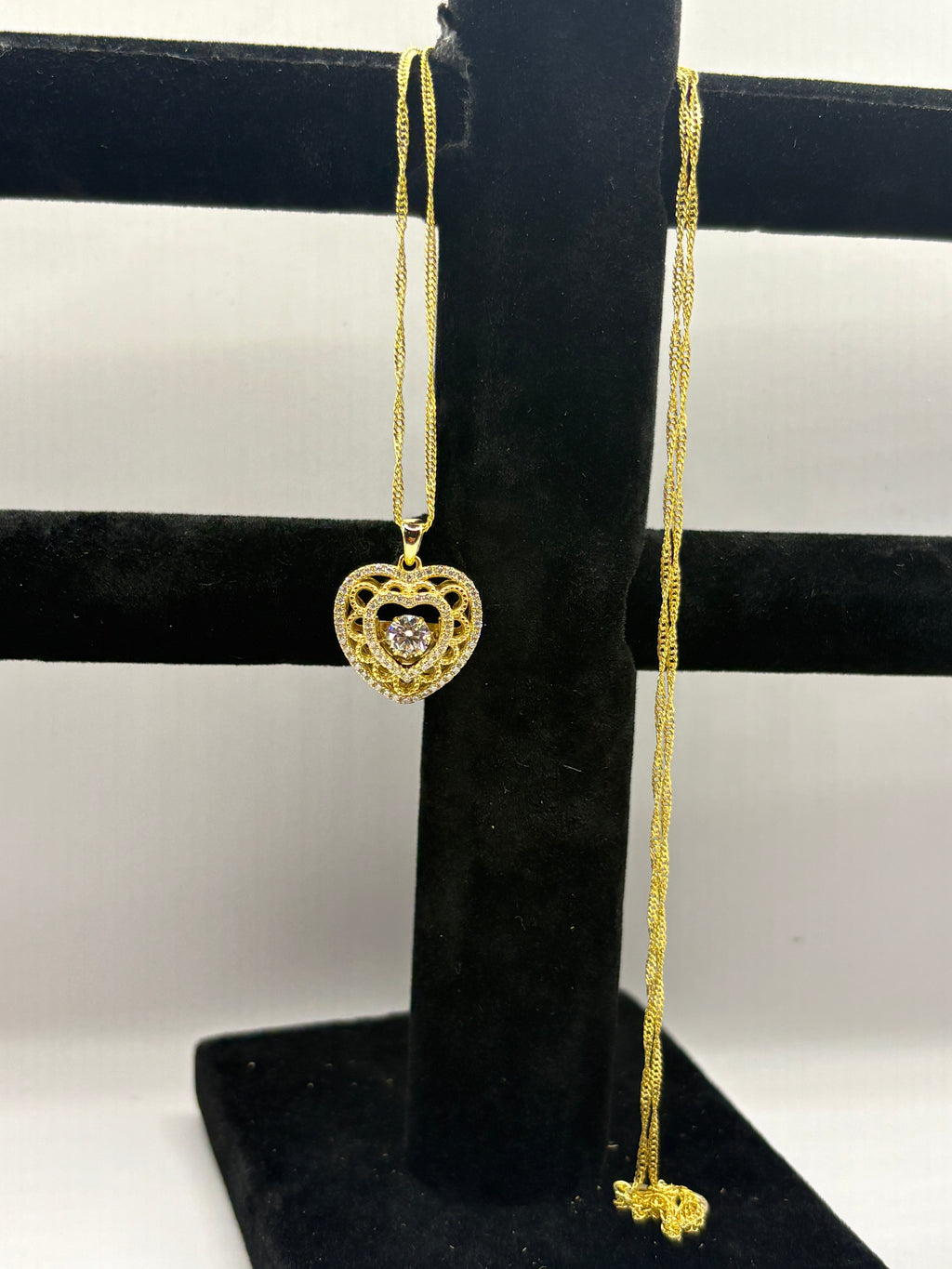 Heart pendant necklace combines romantic filigree detailing with brilliant moissanite accents for an elegant, eye-catching style.