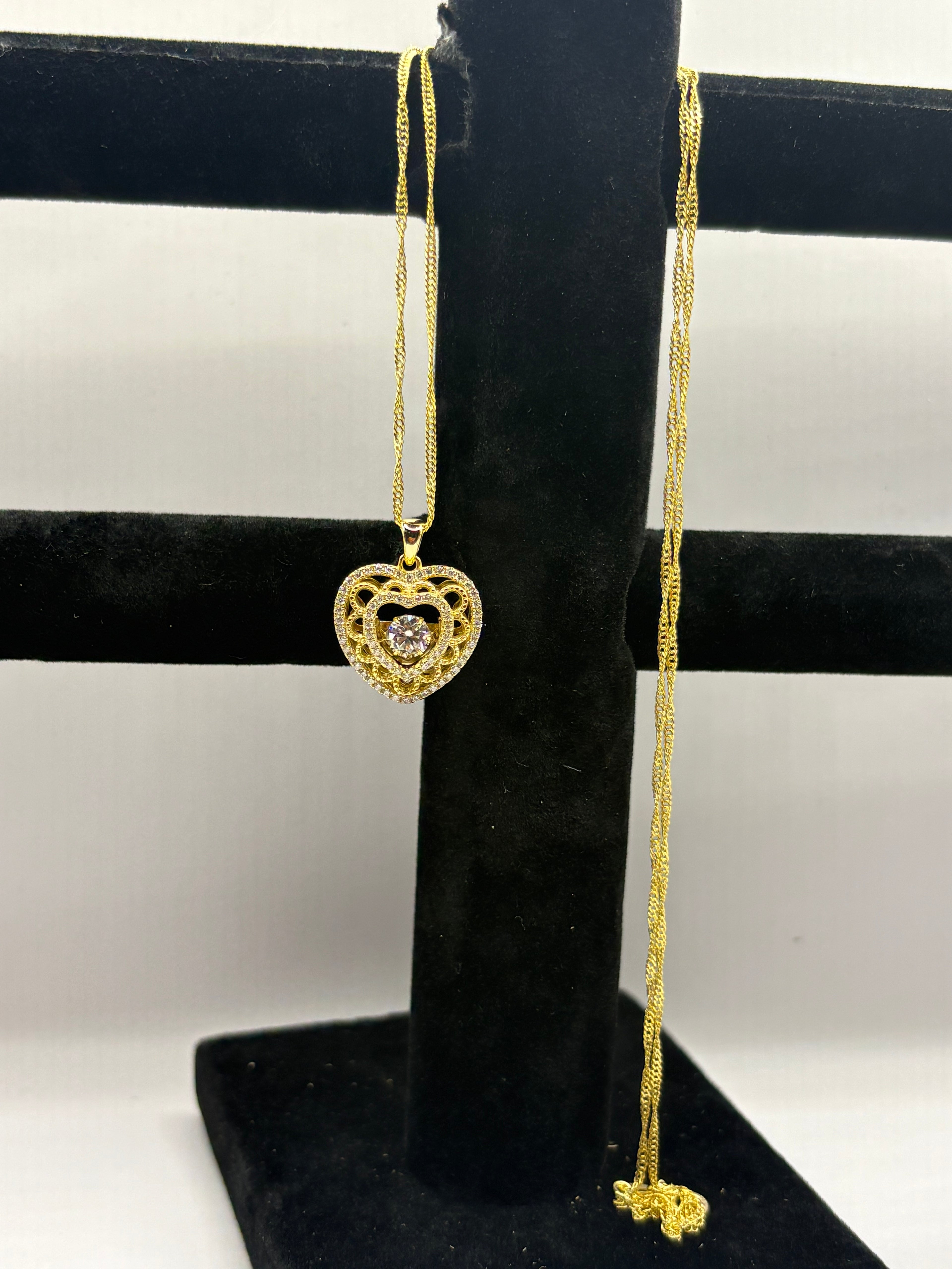 Heart pendant necklace combines romantic filigree detailing with brilliant moissanite accents for an elegant, eye-catching style.