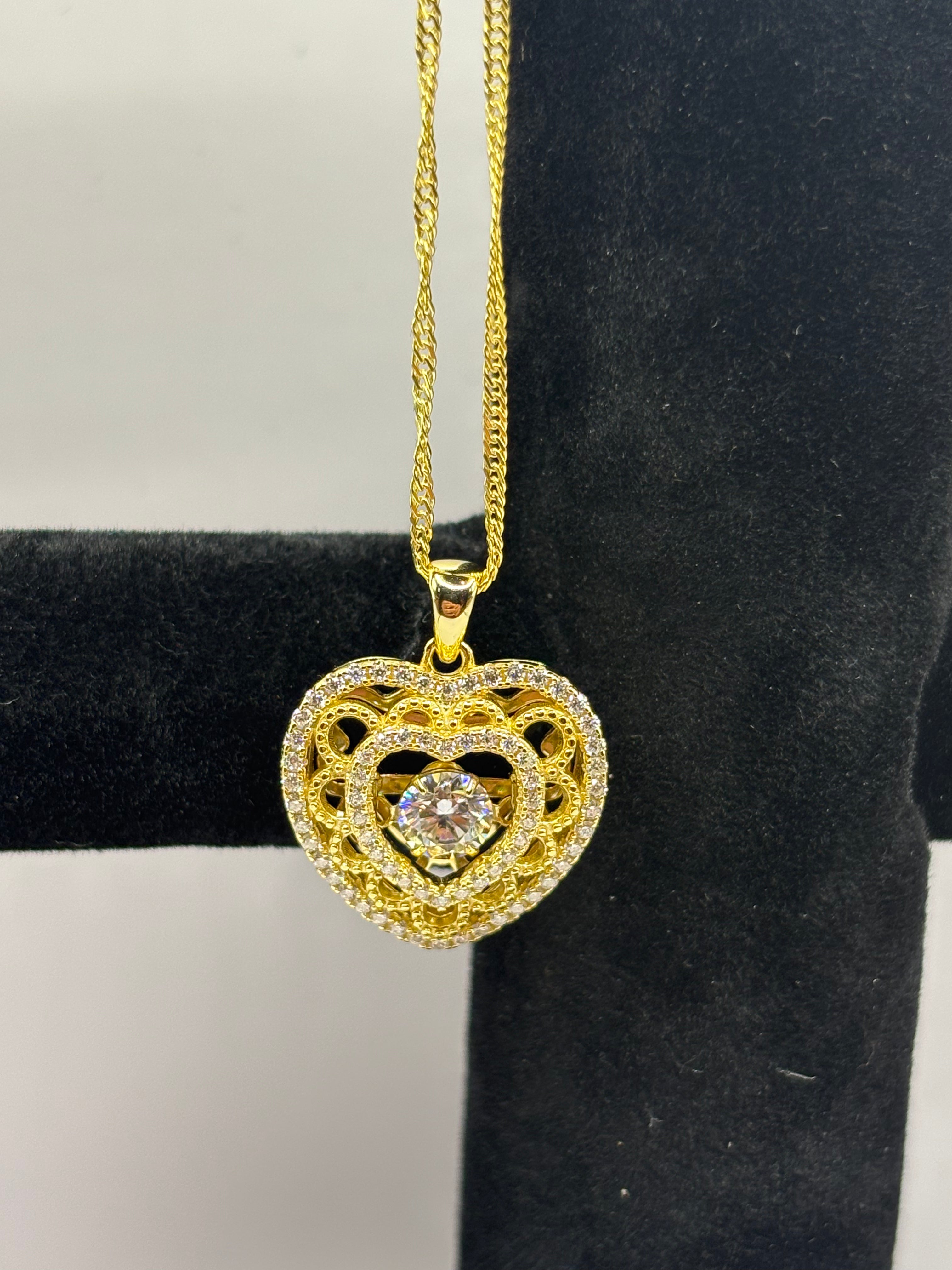 Heart pendant necklace combines romantic filigree detailing with brilliant moissanite accents for an elegant, eye-catching style.