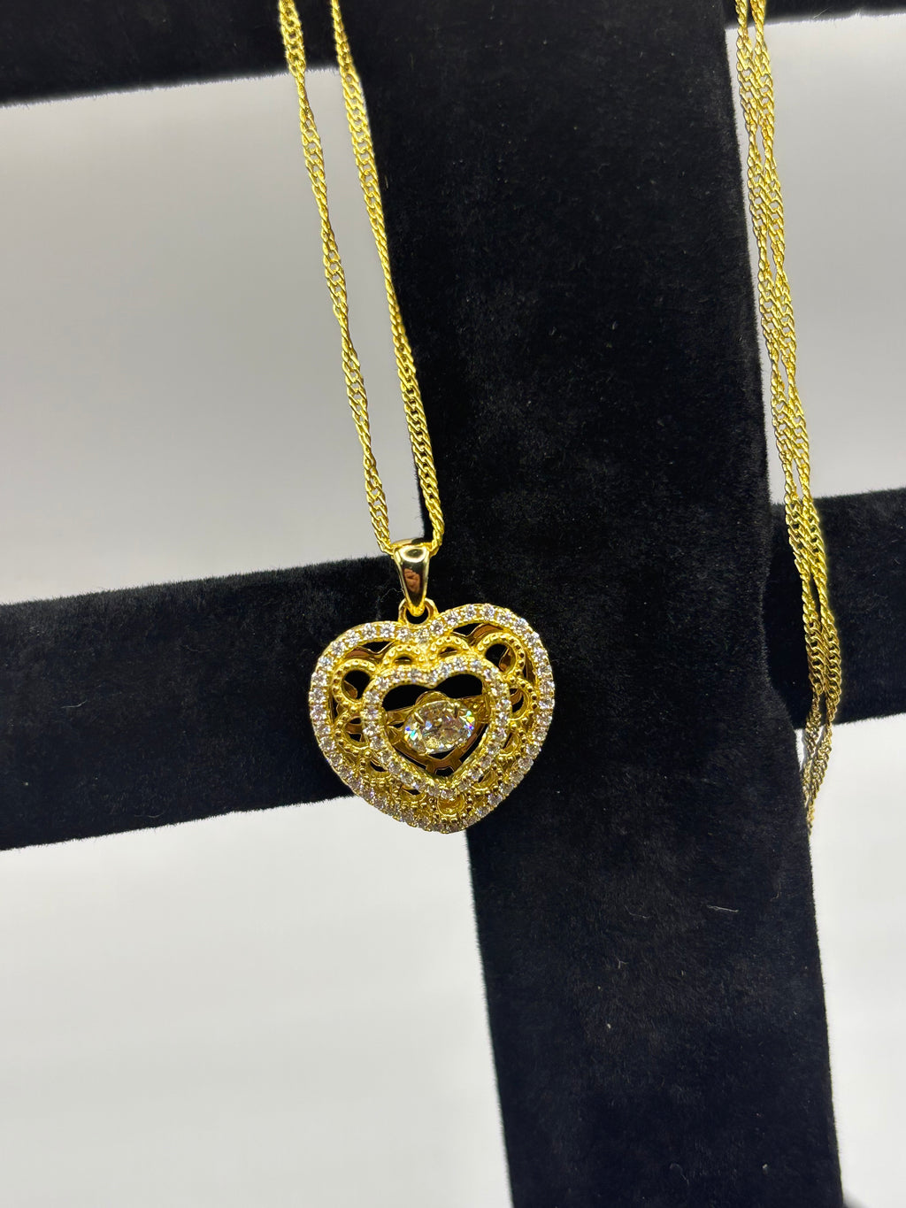 Heart pendant necklace combines romantic filigree detailing with brilliant moissanite accents for an elegant, eye-catching style.