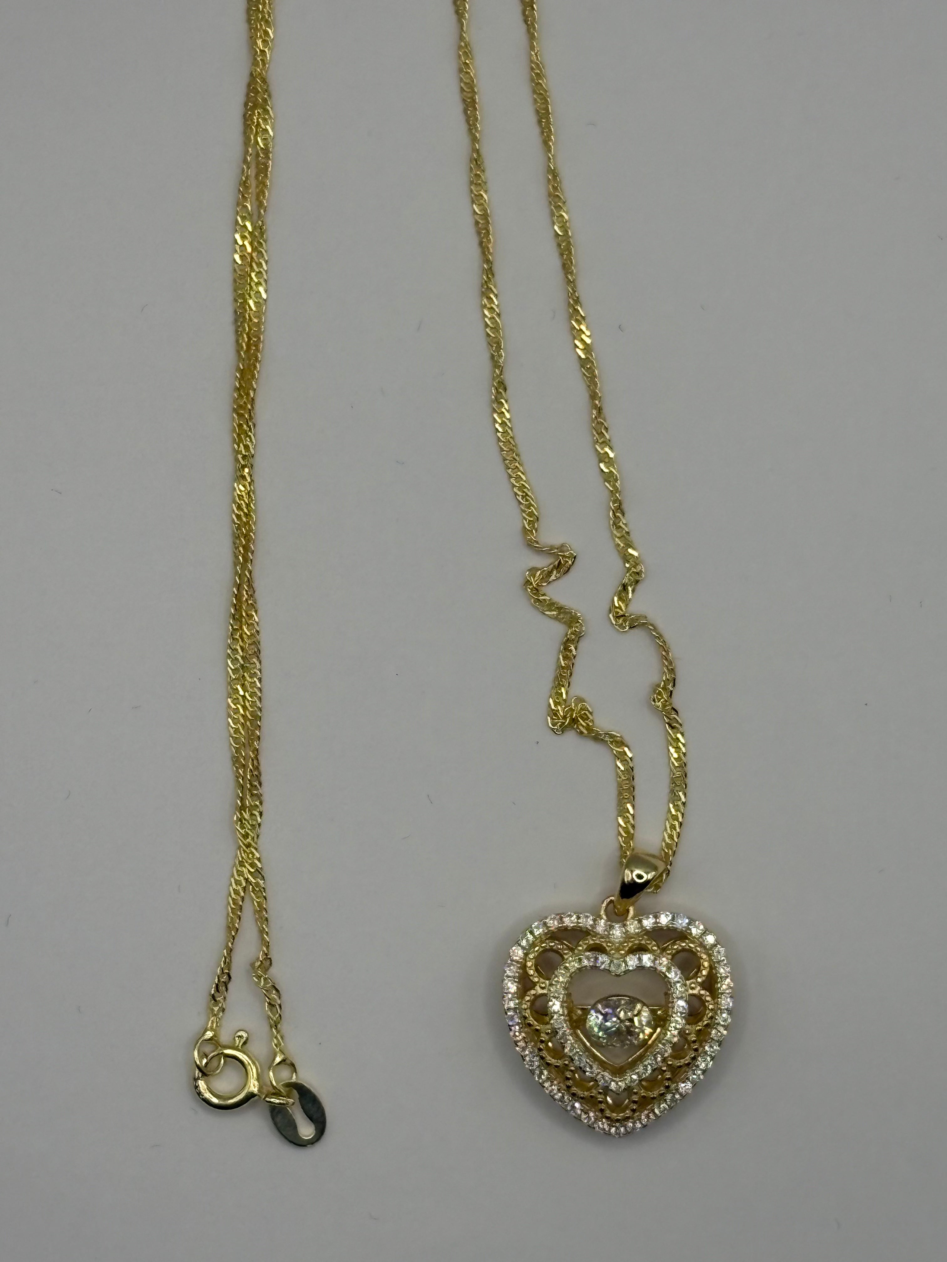 Heart pendant necklace combines romantic filigree detailing with brilliant moissanite accents for an elegant, eye-catching style.